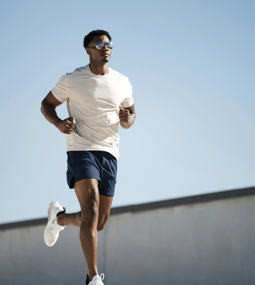 Man running down the street in shirt and shorts